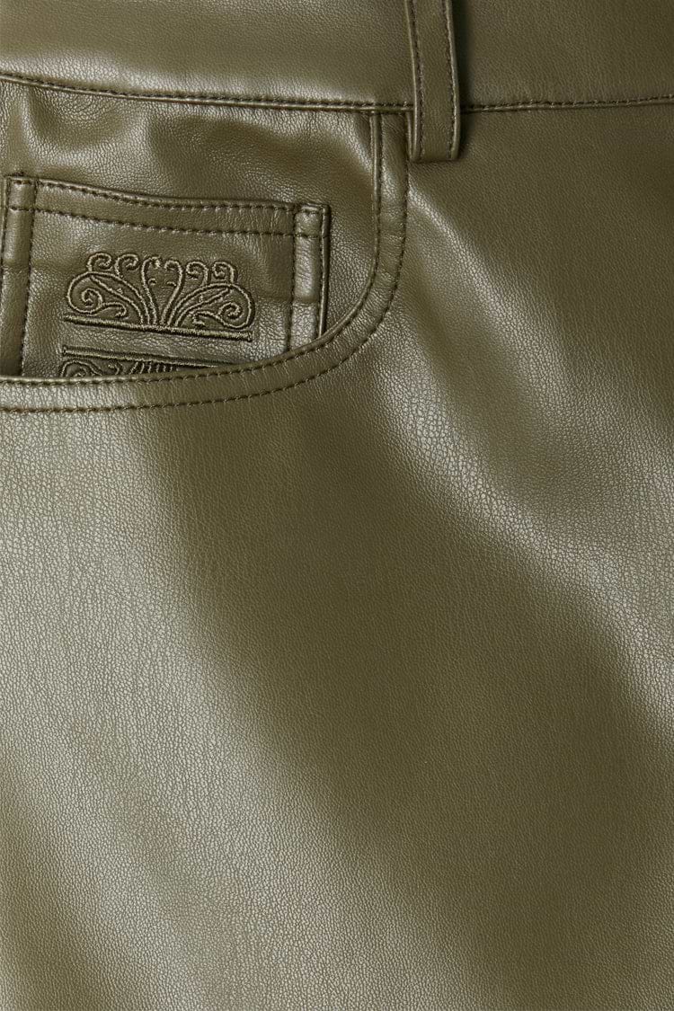 Khaki vegan leather trousers featuring a detailed view of the front pocket and signature embroidered logo.