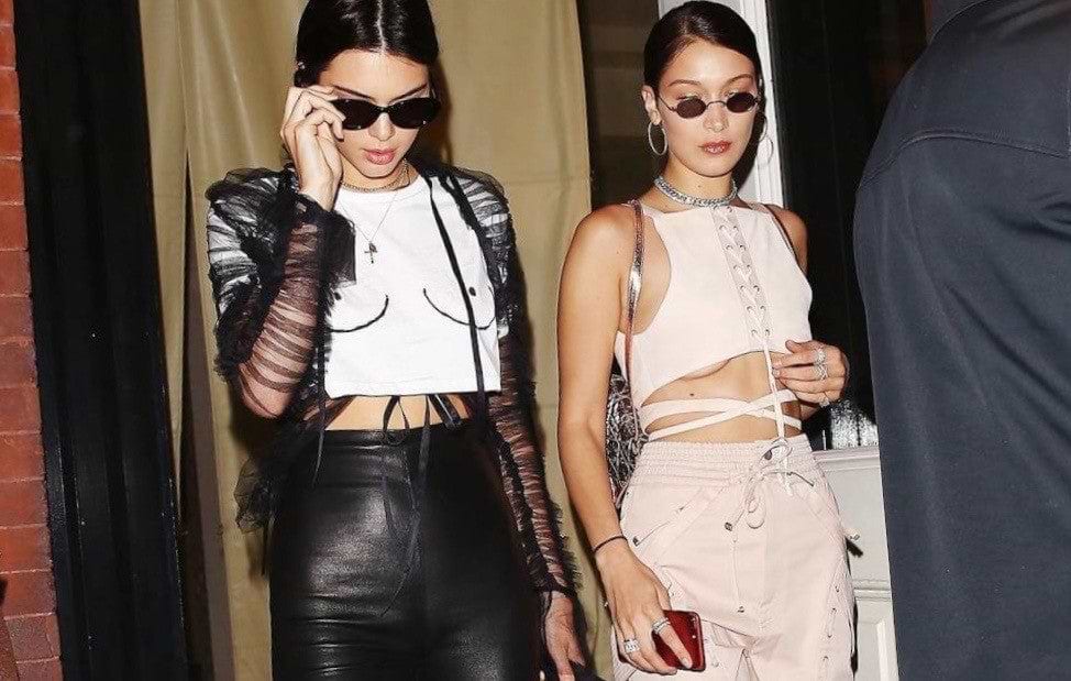 Iconic white Boob T-shirt worn by Kendall Jenner with black leather trousers and a sheer mesh jacket.