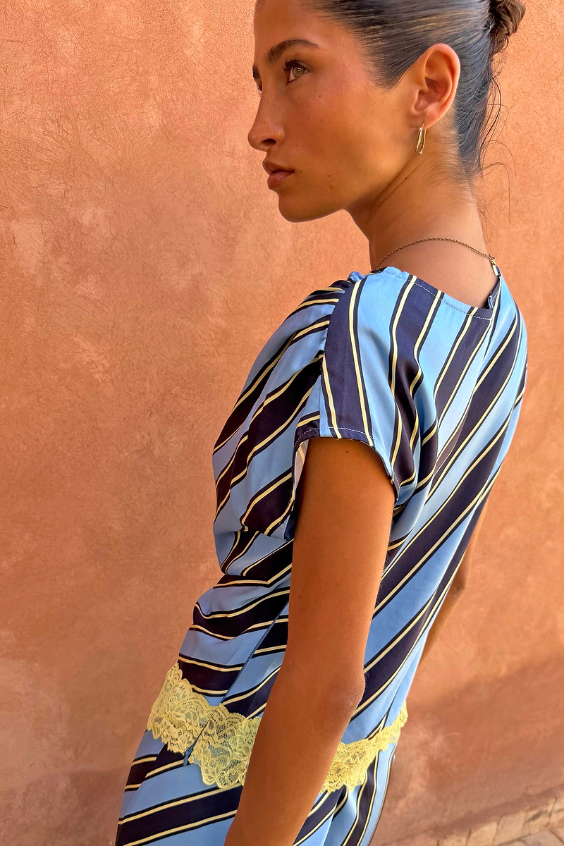 Stripe A-Symmetrical Top in blue and navy with yellow lace trim, shown in a side profile view.