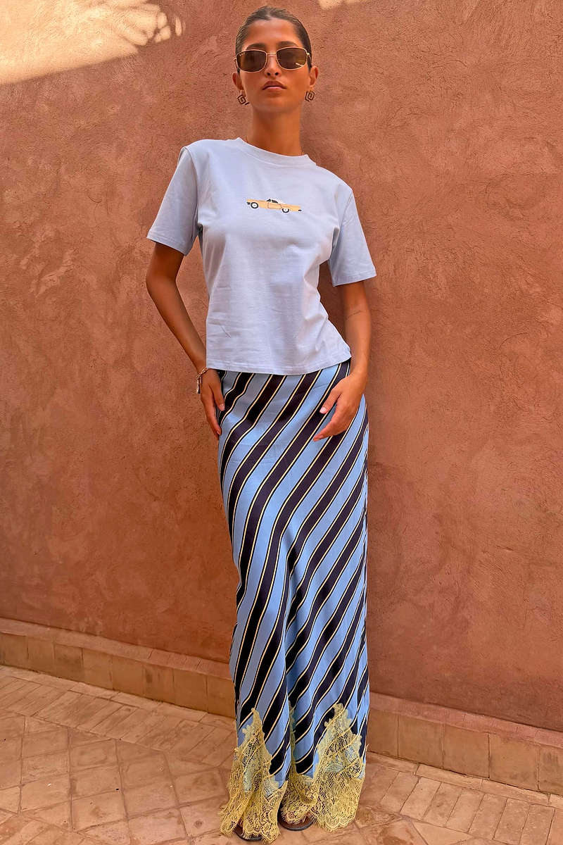 Stripe Maeva Skirt with blue diagonal stripes and a yellow lace hem, styled with a light blue tee.