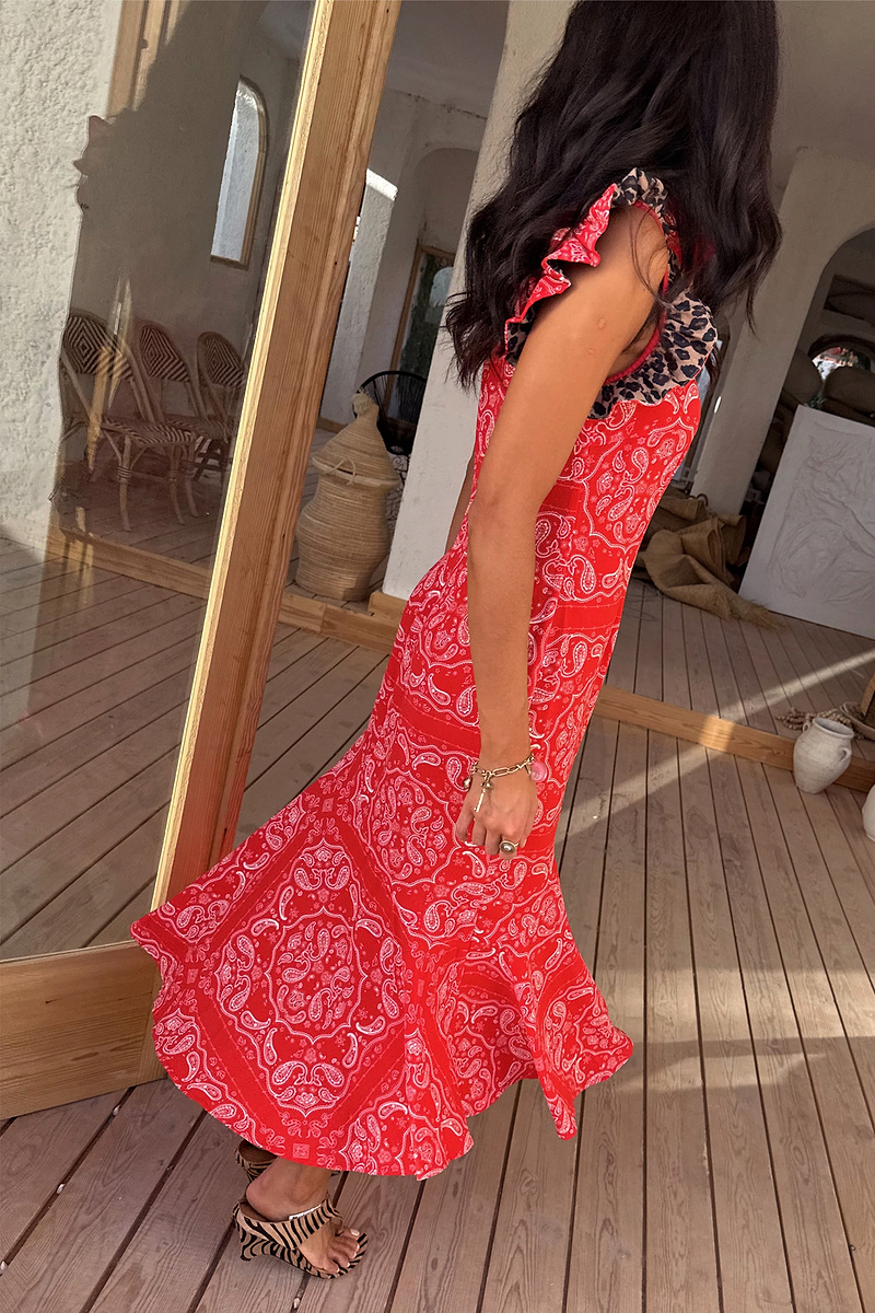 Red Bandana Remi Dress featuring leopard print frill sleeves and an asymmetrical hem on a sunlit wooden deck.