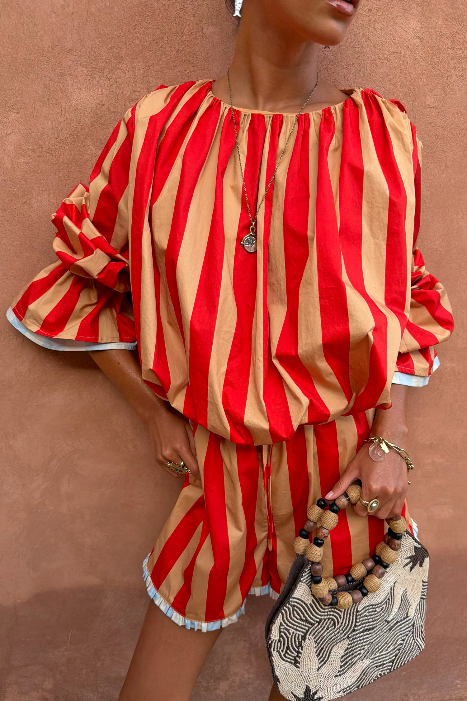 Tomato Stripe Blouse in red and camel stripes with voluminous sleeves and gathered neckline, styled as a vacation co-ord.