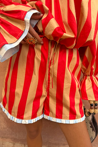 Tomato Stripe Ellie Shorts featuring red and camel stripes, a drawstring waist and blue frill hem.
