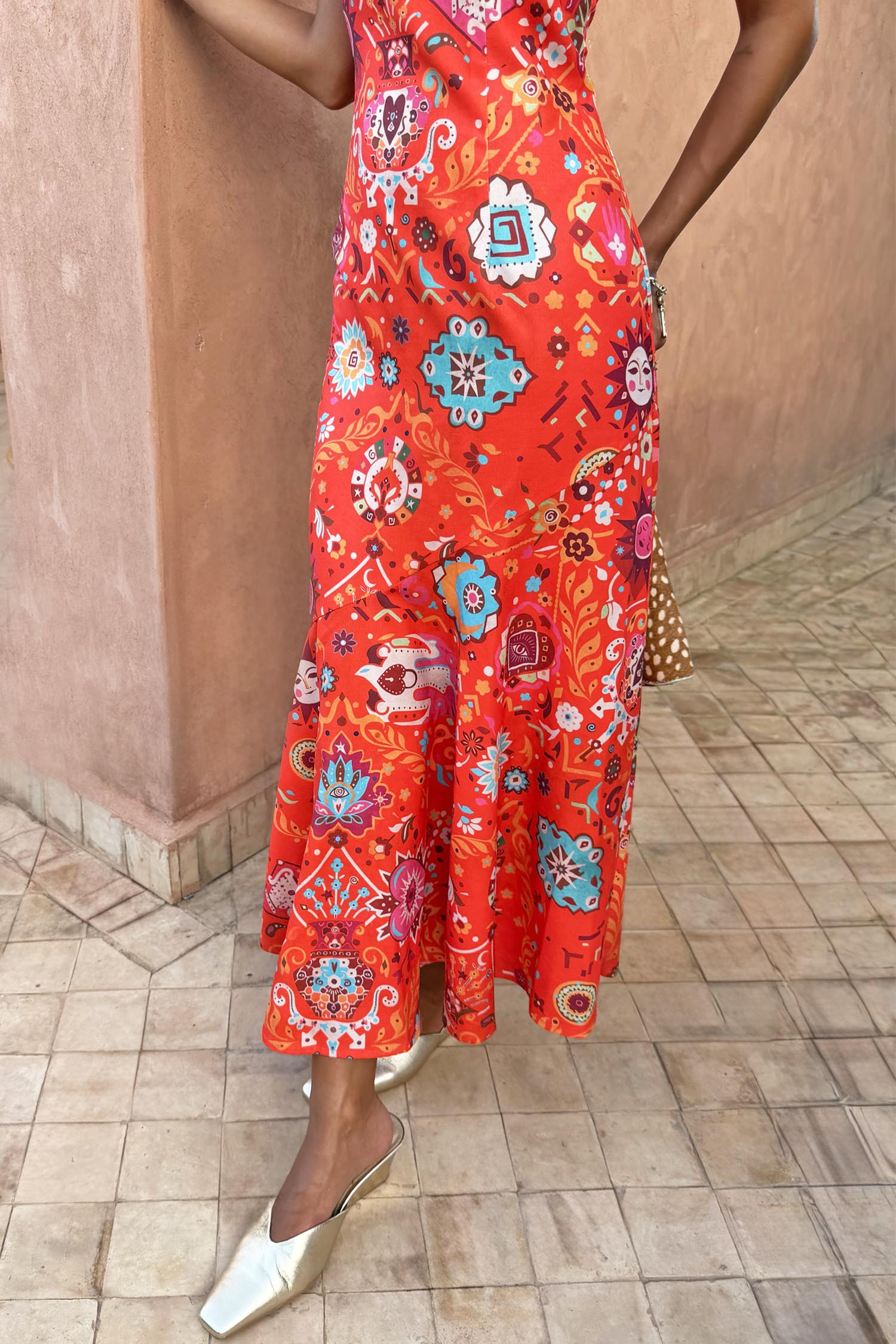 Red Tomato Tapestry Frida Dress featuring a sun motif patchwork print and fluted hem, styled with gold mules.