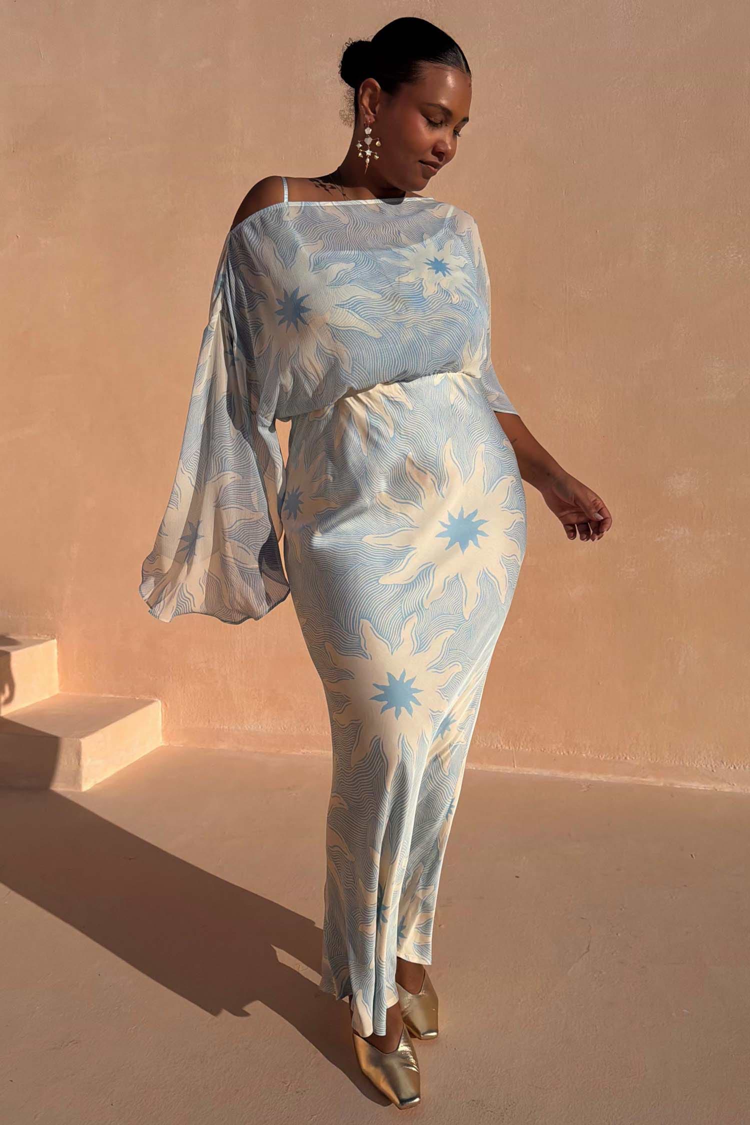 Blue Soleil Anais Dress with sun motifs, off-the-shoulder top and a bias cut maxi skirt on a curve model.