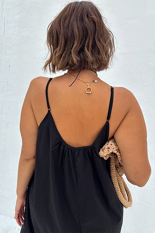 Black Rio Maxi Dress featuring a gathered scoop back and adjustable spaghetti straps, styled with a gold necklace.