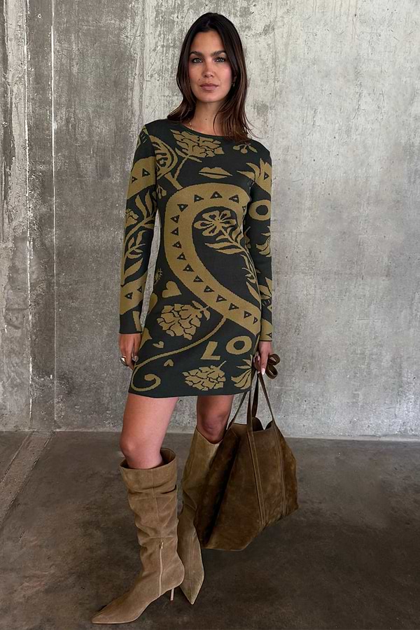 Olive Amara Knit Mini Dress with iconic motifs, styled with tall tan boots and a large brown suede tote bag.