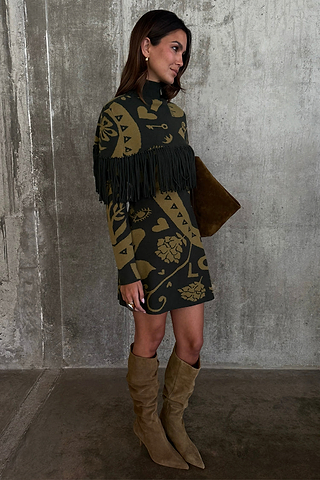 Olive Amara Knit Mini Dress featuring a fringe chest detail and gold motifs, styled with slouchy tan boots.