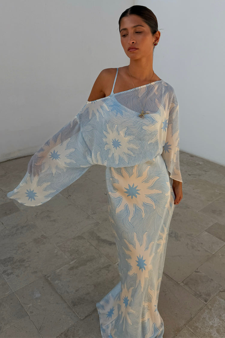Blue Soleil Anais Dress featuring a sheer off-the-shoulder draped top and sun motif print on a bias-cut skirt.