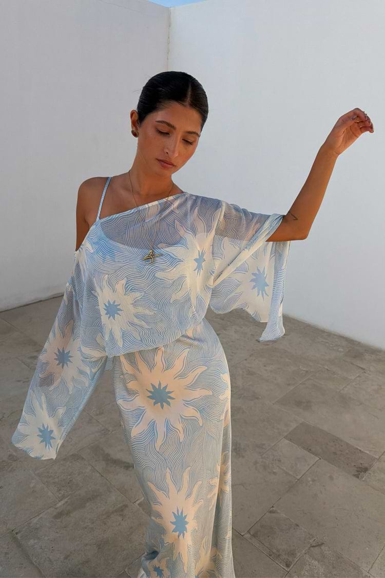 Blue Soleil Anais Dress with a Mediterranean sun print, sheer off-the-shoulder top and long bias cut skirt.
