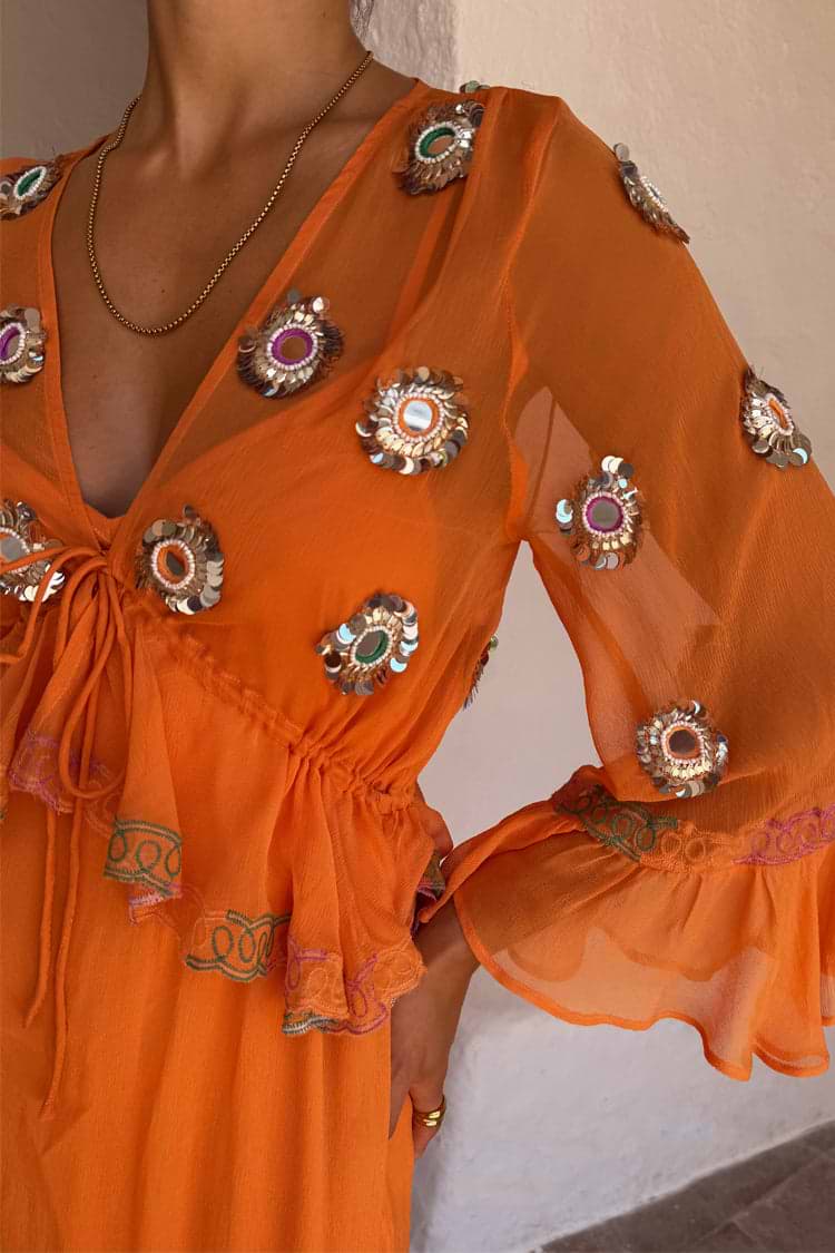 Apricot Embellished Ines Dress in orange sheer fabric with hand-embroidered mirror detailing and a ruffled peplum.