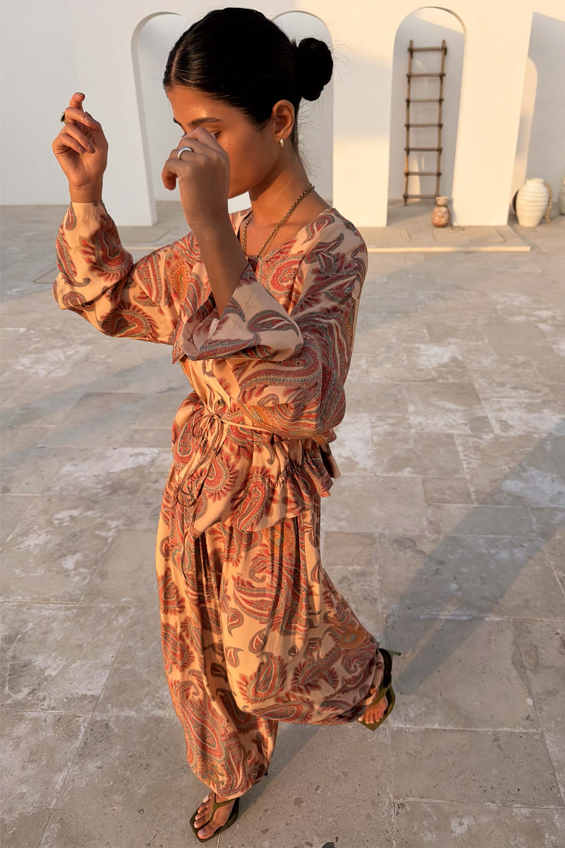 Peach Paisley Balloon Trousers and matching top co-ord in a sun-drenched outdoor setting.