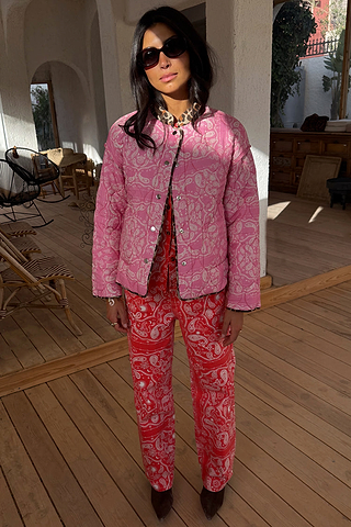 Reversible pink quilted jacket with a bandana print and leopard trim, paired with matching red bandana trousers.
