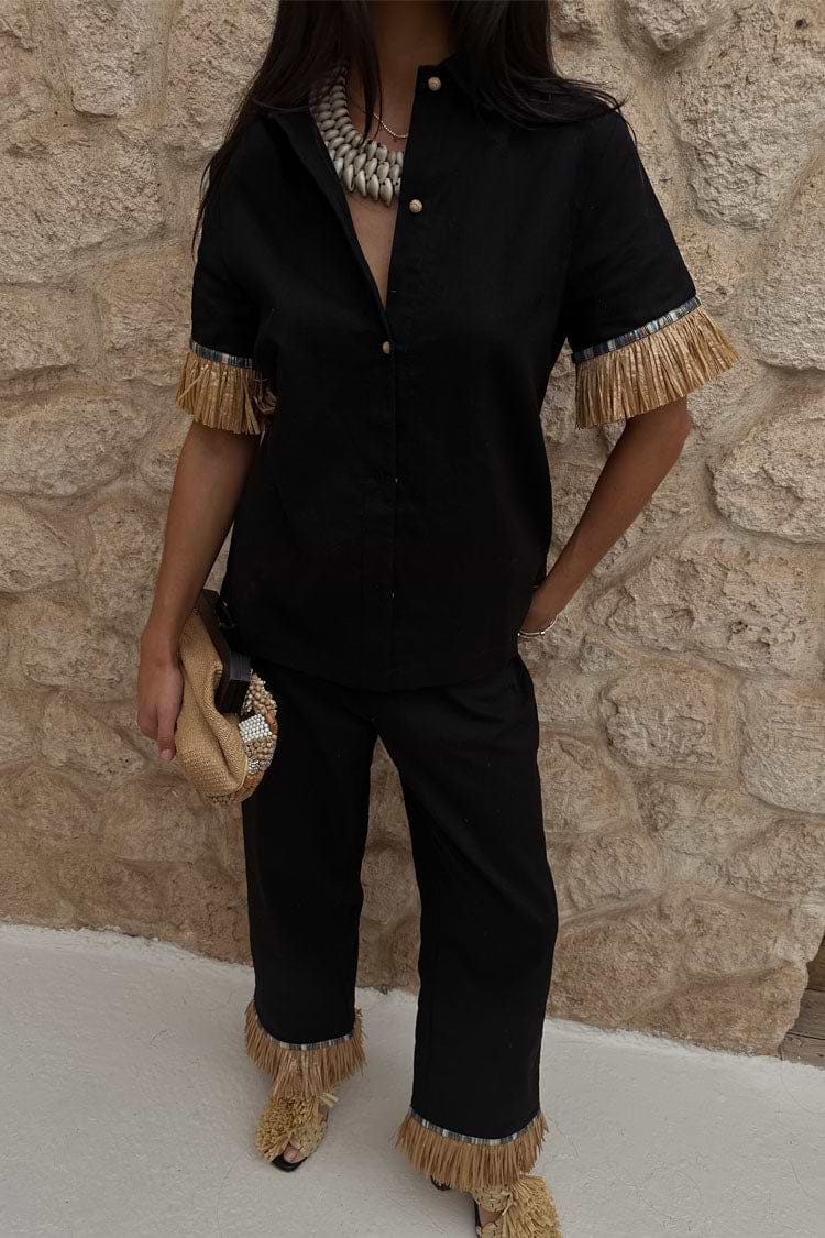 Black Raffia Marra Trousers with fringe hems, styled as a co-ord with a matching shirt and raffia clutch.