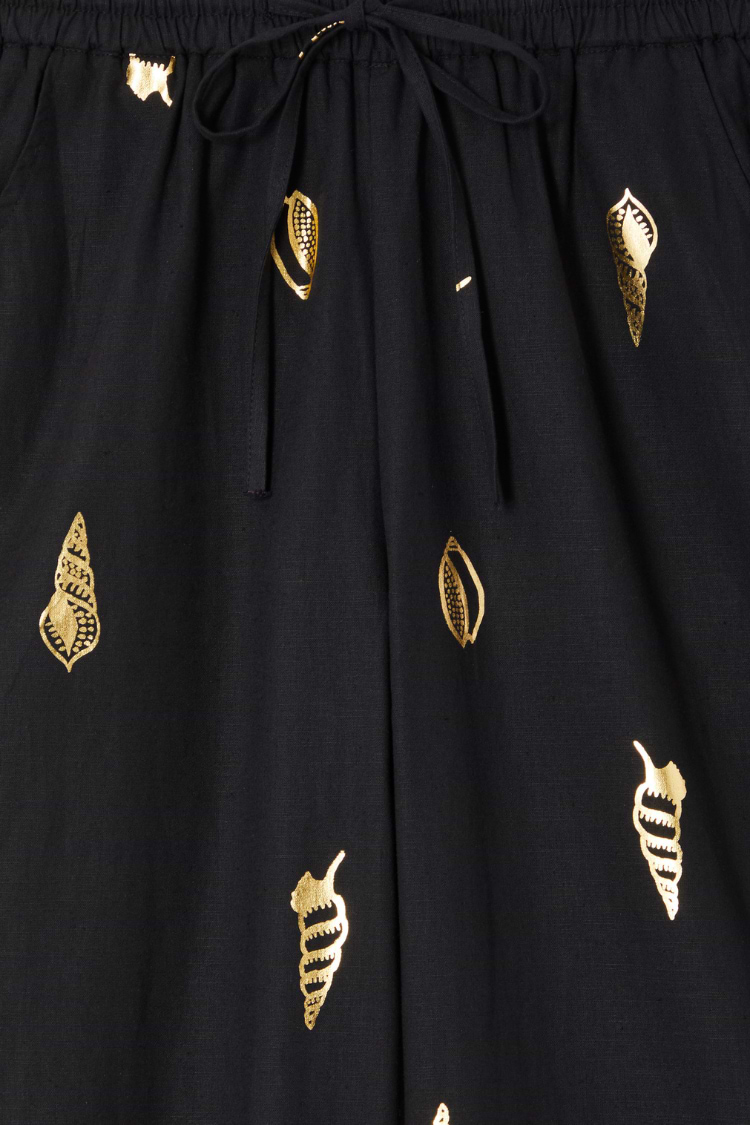 Black Shell Elissa Trousers detail showing the elasticated drawstring waist and metallic gold shell print.