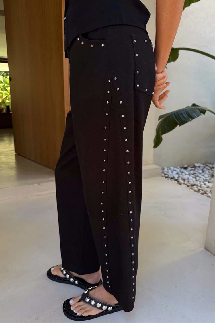 Black Studded Barrel Jeans featuring silver studs along the side and pockets, styled with studded sandals.