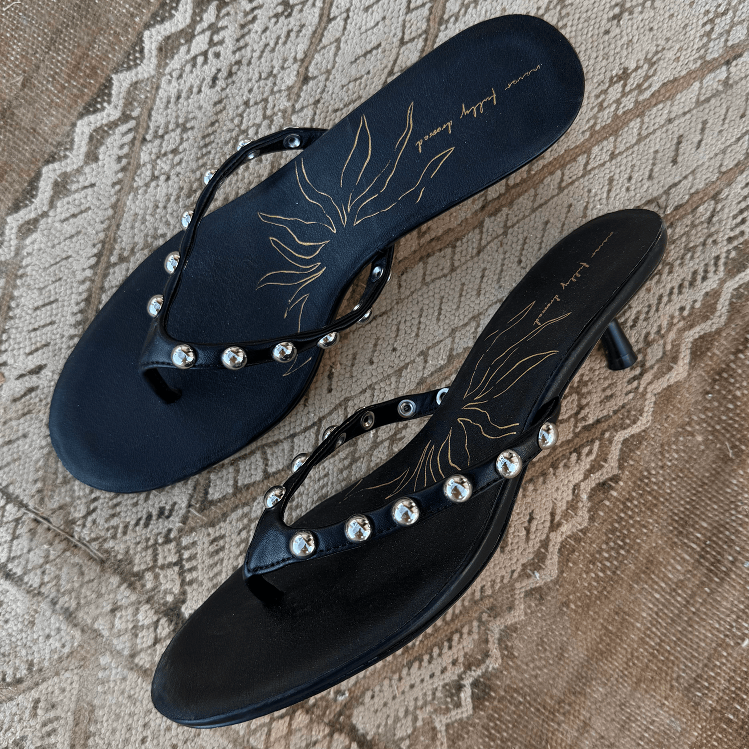 Black Stud Sandal Mule in leather with silver studs and a signature gold sun motif on the cushioned sole.