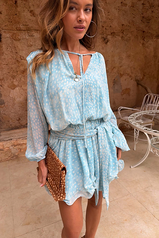 Blue Fawn Ella Mini Dress with a deer print, flute sleeves and tiered ruffles, styled with a leopard clutch.