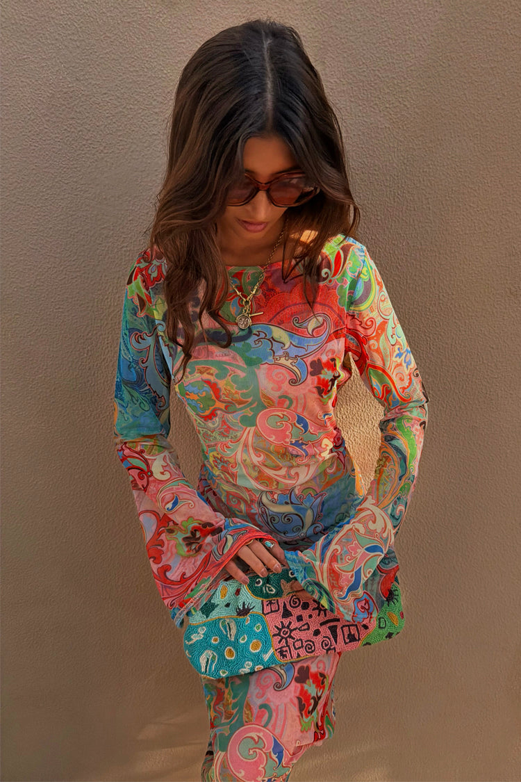 Blue Mari Aria Mesh Dress with a multi-colour paisley print, flared sleeves and a beaded clutch bag.