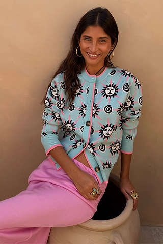 NFD Blue Sun Hollie Cardigan in baby blue soft-touch knit with a pink sun print, worn by a model.
