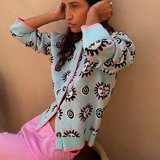 Blue Sun Hollie Cardigan in baby blue knit with pink sun motifs, contrast trim and button front, worn by a model.