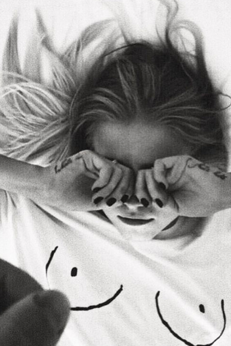Iconic white Boob T-shirt with line drawing detail on a model lying down in black and white.