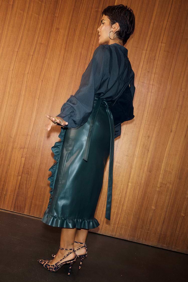 Bottle Green Vegan Leather Ruffle Jaspre Skirt with a wrap tie and frill hem, styled with leopard print heels.