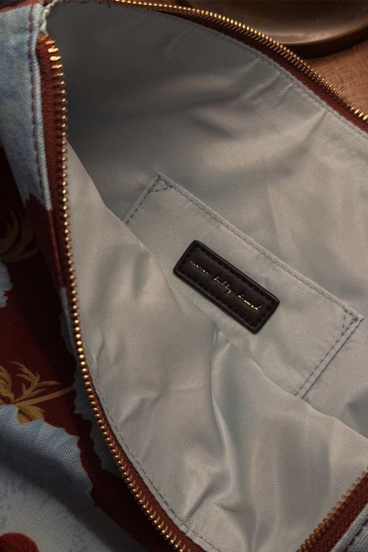 Blue & Burgundy Poppy Laptop Case interior showing the pale blue lining, internal pocket and gold brand label detail.