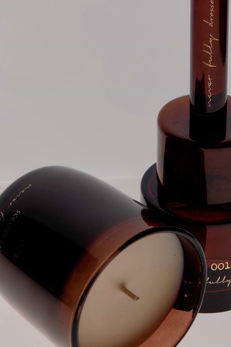 Amber glass NFD Eau De Parfum Candle 001 featuring gold script branding and a visible wick.