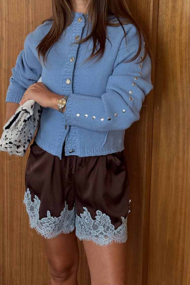 Chocolate satin shorts with ice blue lace trim, styled with a light blue studded cardigan and printed clutch.