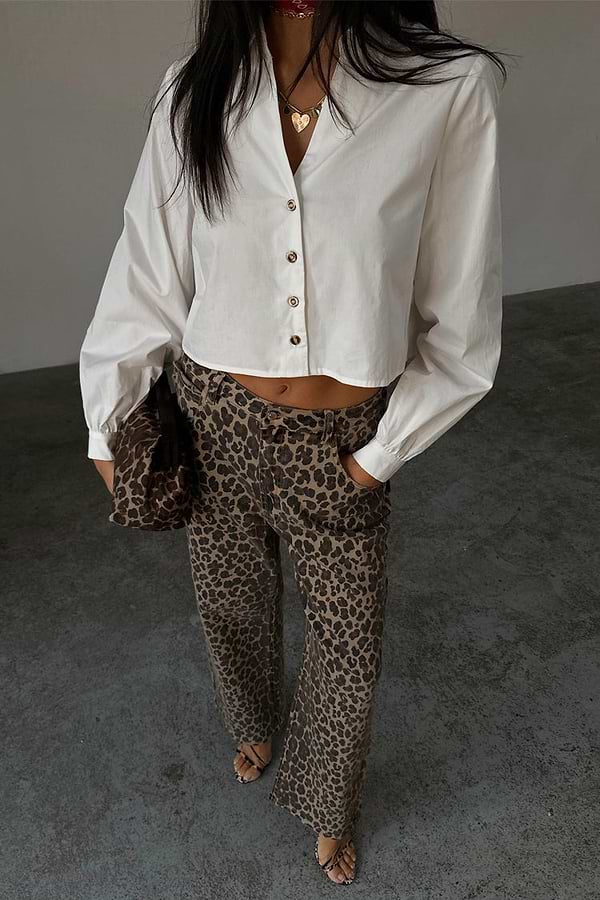 White Cropped Cotton Miley Shirt with blouson sleeves and tortoise buttons, paired with leopard print trousers.