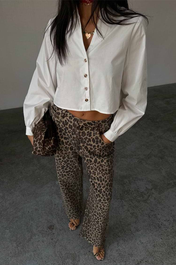 White Cropped Cotton Miley Shirt with blouson sleeves and tortoise buttons, paired with leopard print trousers.