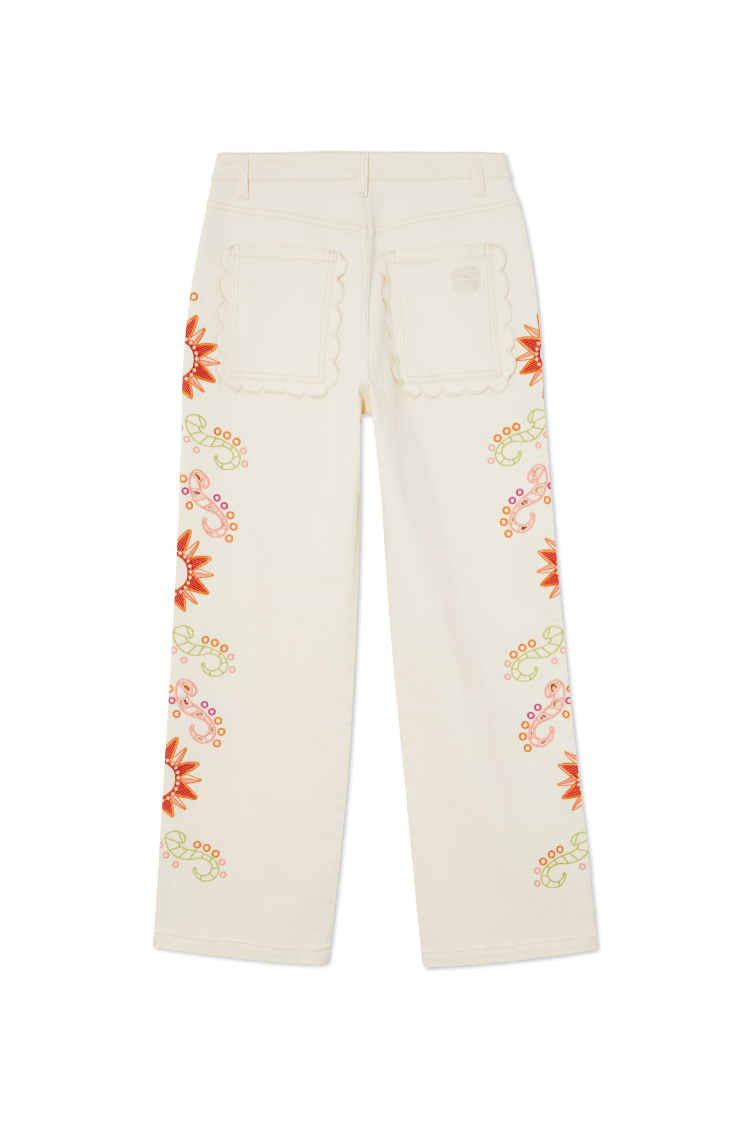 Ecru wide leg jeans featuring scalloped back pockets and colourful sun embroidery along the side seams.