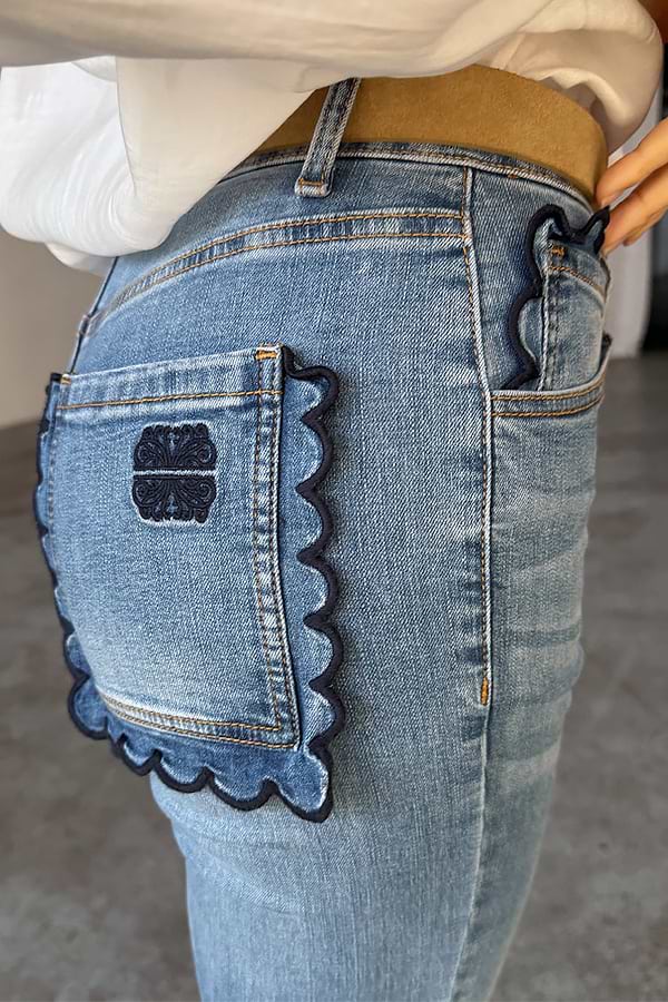 NFD Denim Flare Scallop Jean in blue with navy scalloped pockets and an embroidered logo on the back.