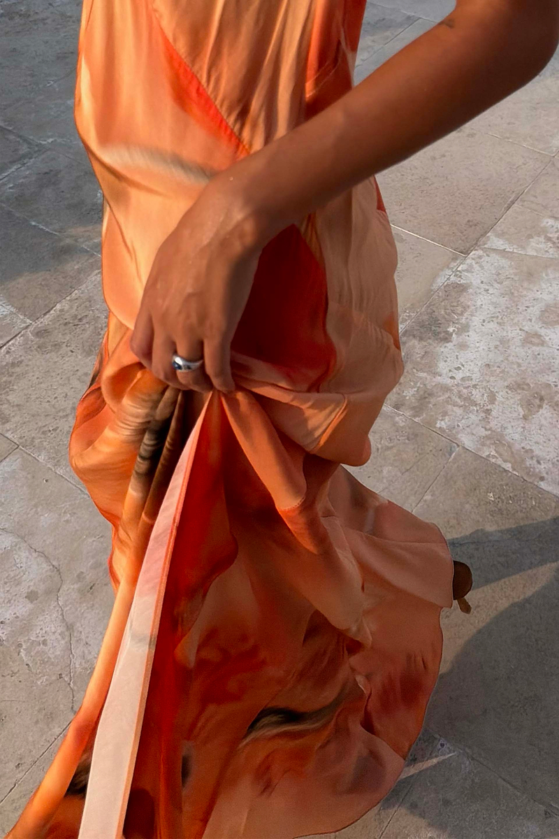 Burnt orange Blurred Floral Sofia Dress highlighting the fluid bias-cut drape and side slit.
