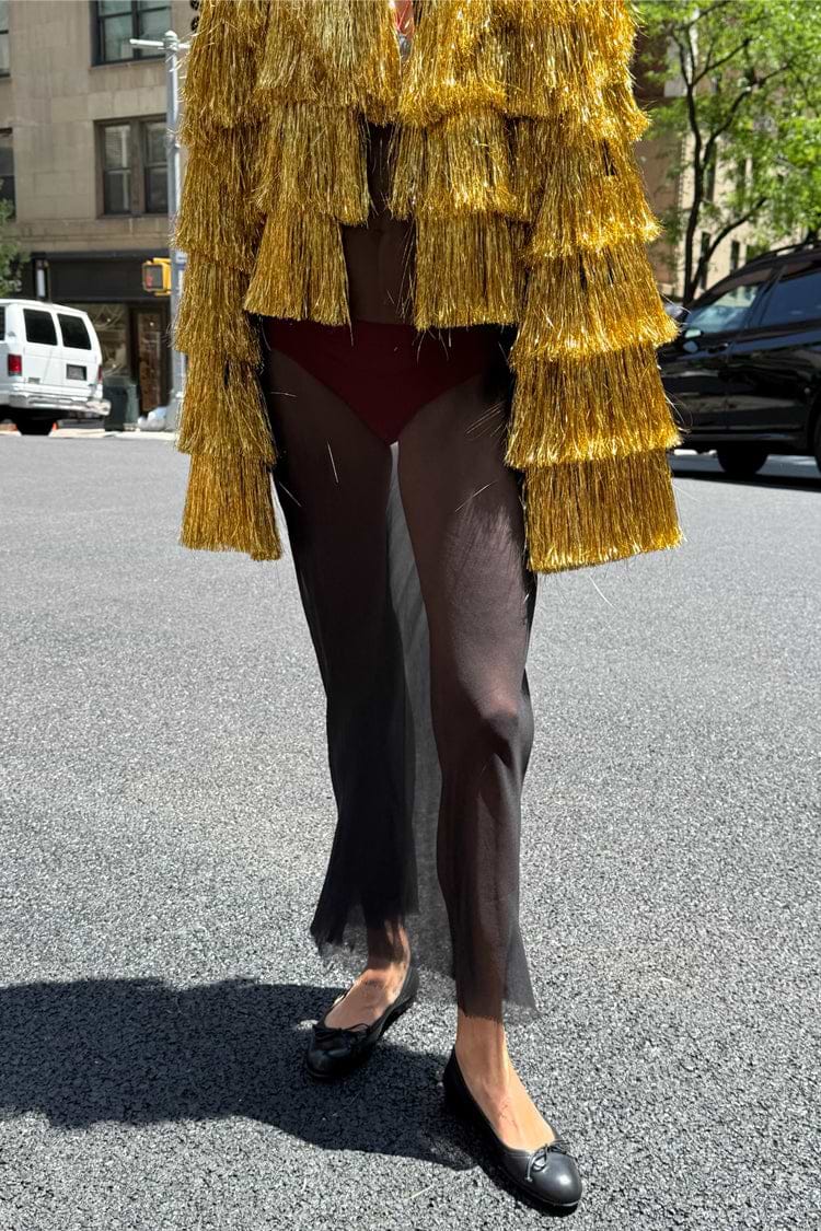 Gold Fringe Jacket with tiered foil tassels, a statement staple styled with a sheer black skirt on a city street.