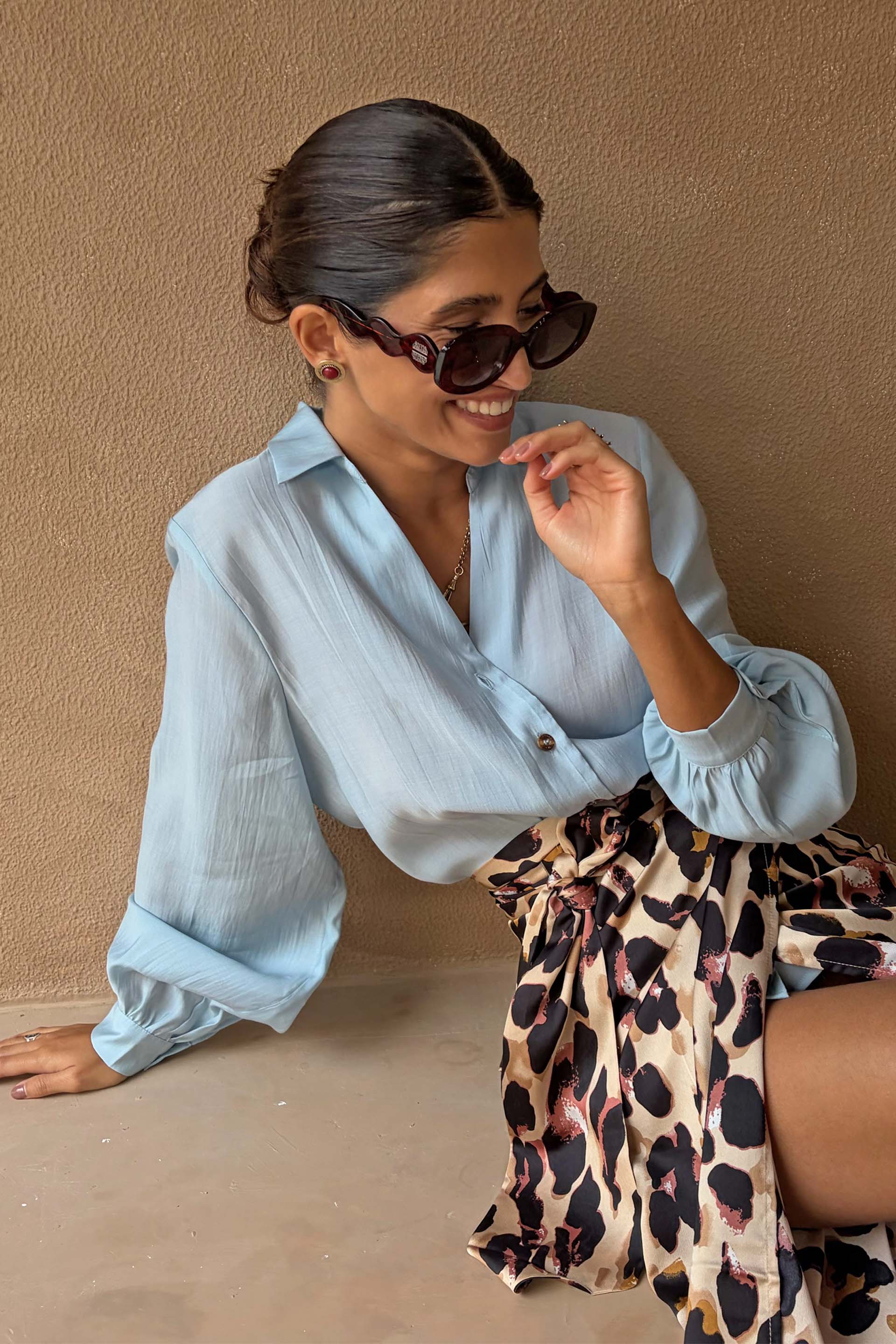 Never Fully Dressed Ice Blue Miley Shirt with blouson sleeves, paired with a leopard print wrap skirt.