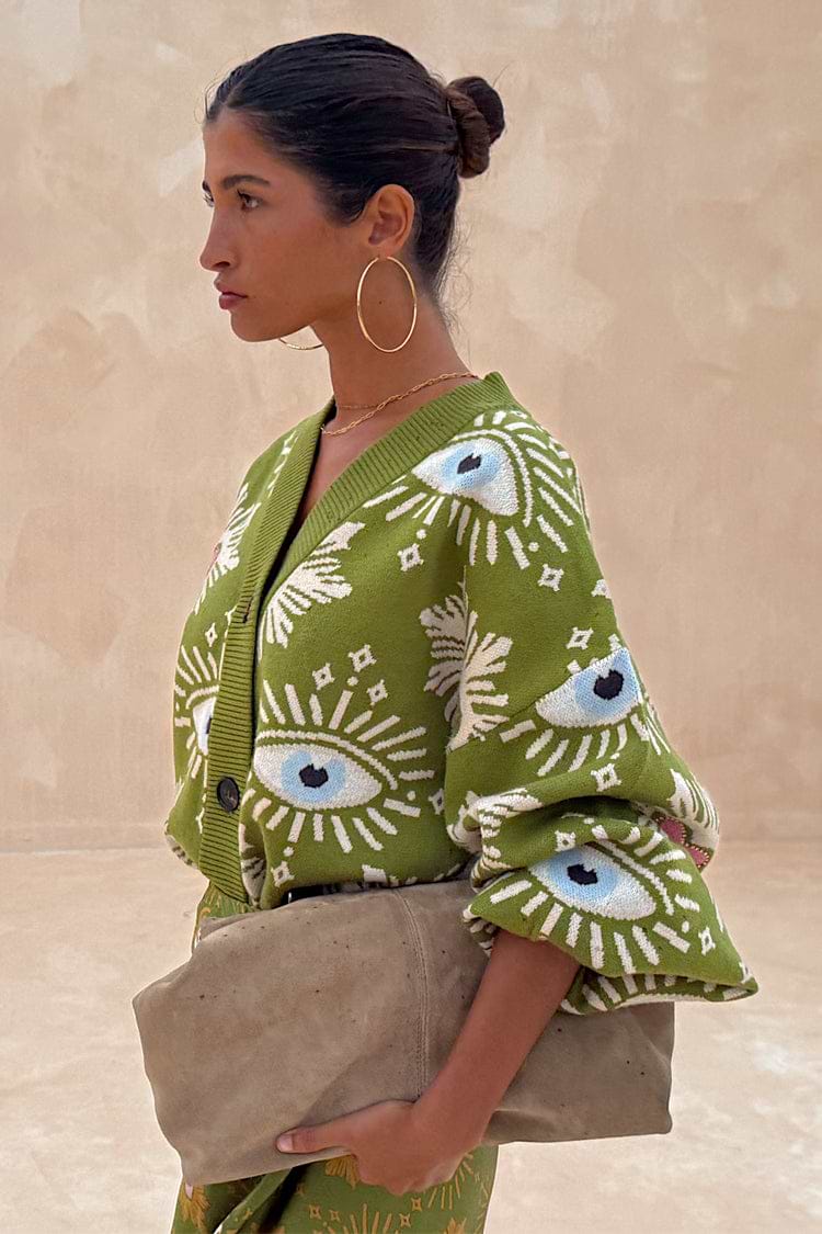 Khaki Eye Cardigan in a soft green knit with iconic eye and heart motifs, shown from a side profile.