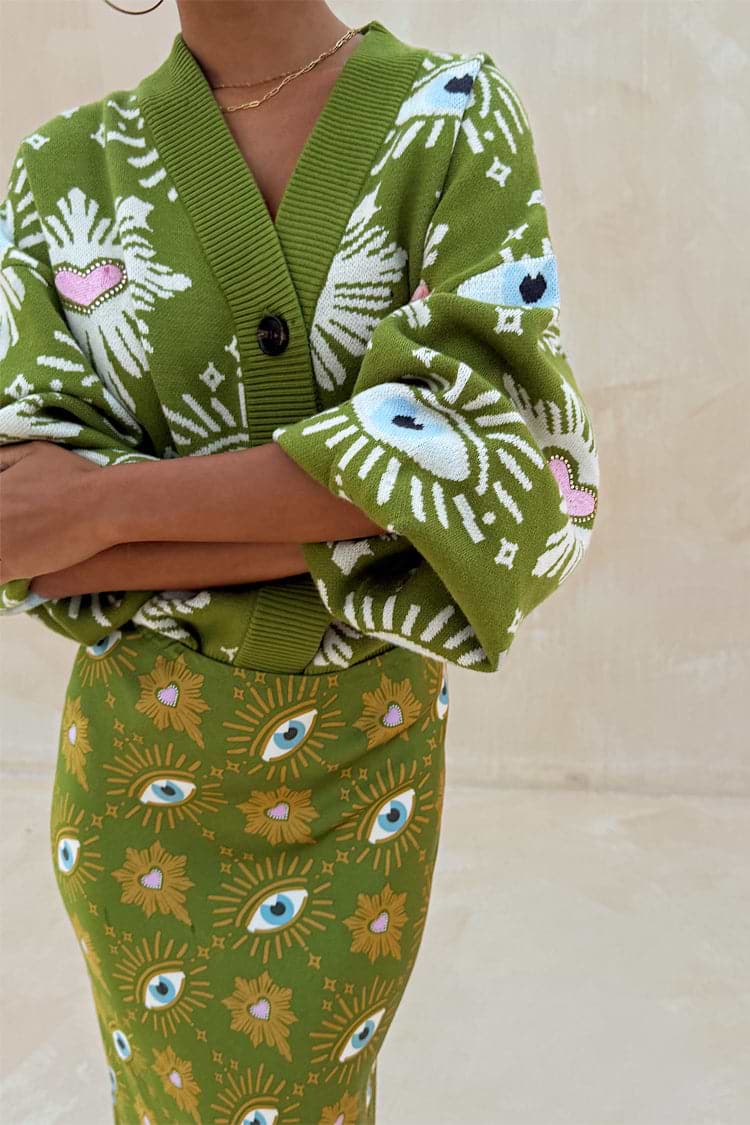 Khaki knit cardigan featuring iconic eye and heart motifs, paired with a matching printed Dorris skirt.