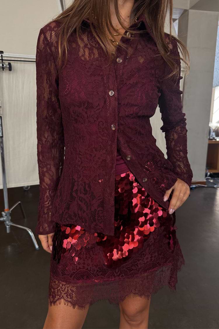 Burgundy Lace Shirt in a delicate lace fabric with flared cuffs, paired with a red sequin mini skirt.