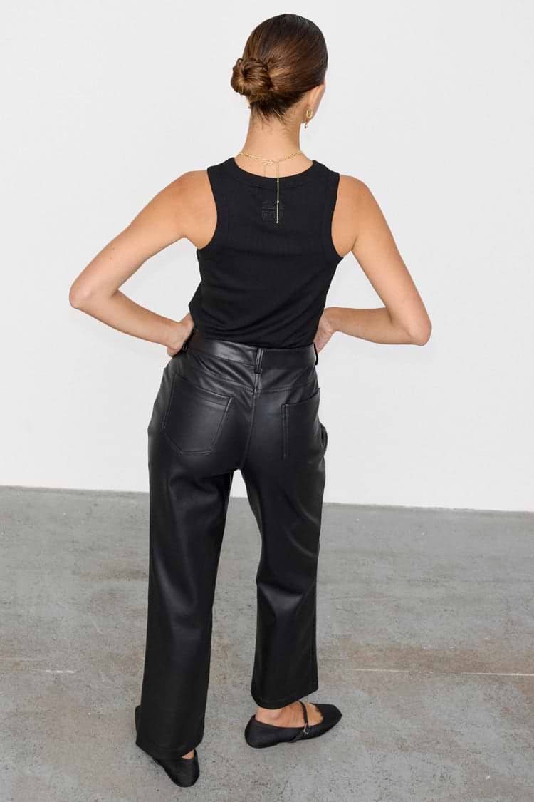 Back view of high-waisted Black Vegan Leather Trousers with a straight leg, paired with a black ribbed tank top.