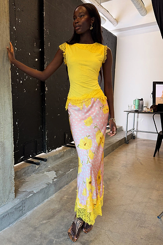 Yellow Lace Insert Top with an asymmetric lace hem and trim, styled with a pink floral skirt.