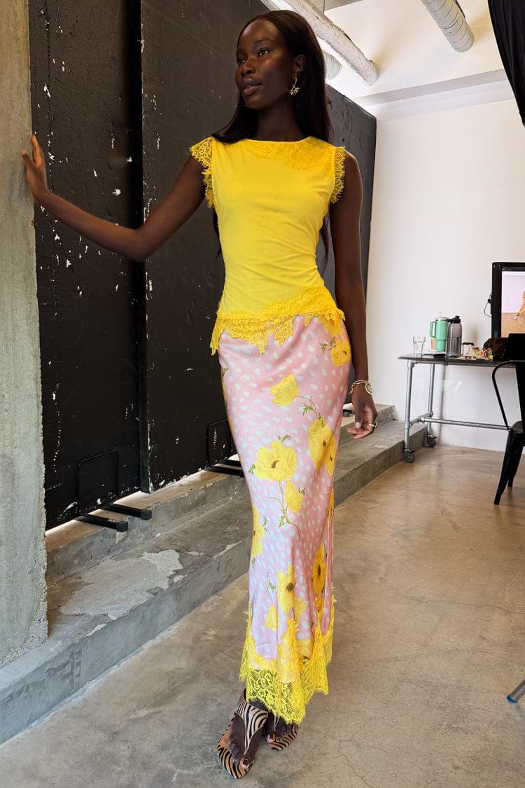 Yellow Lace Insert Top with an asymmetric lace hem and trim, styled with a pink floral skirt.