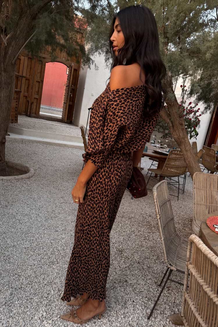 Lucia Leopard Tilly Dress in plisse with an off-the-shoulder neckline, styled in an outdoor garden setting.