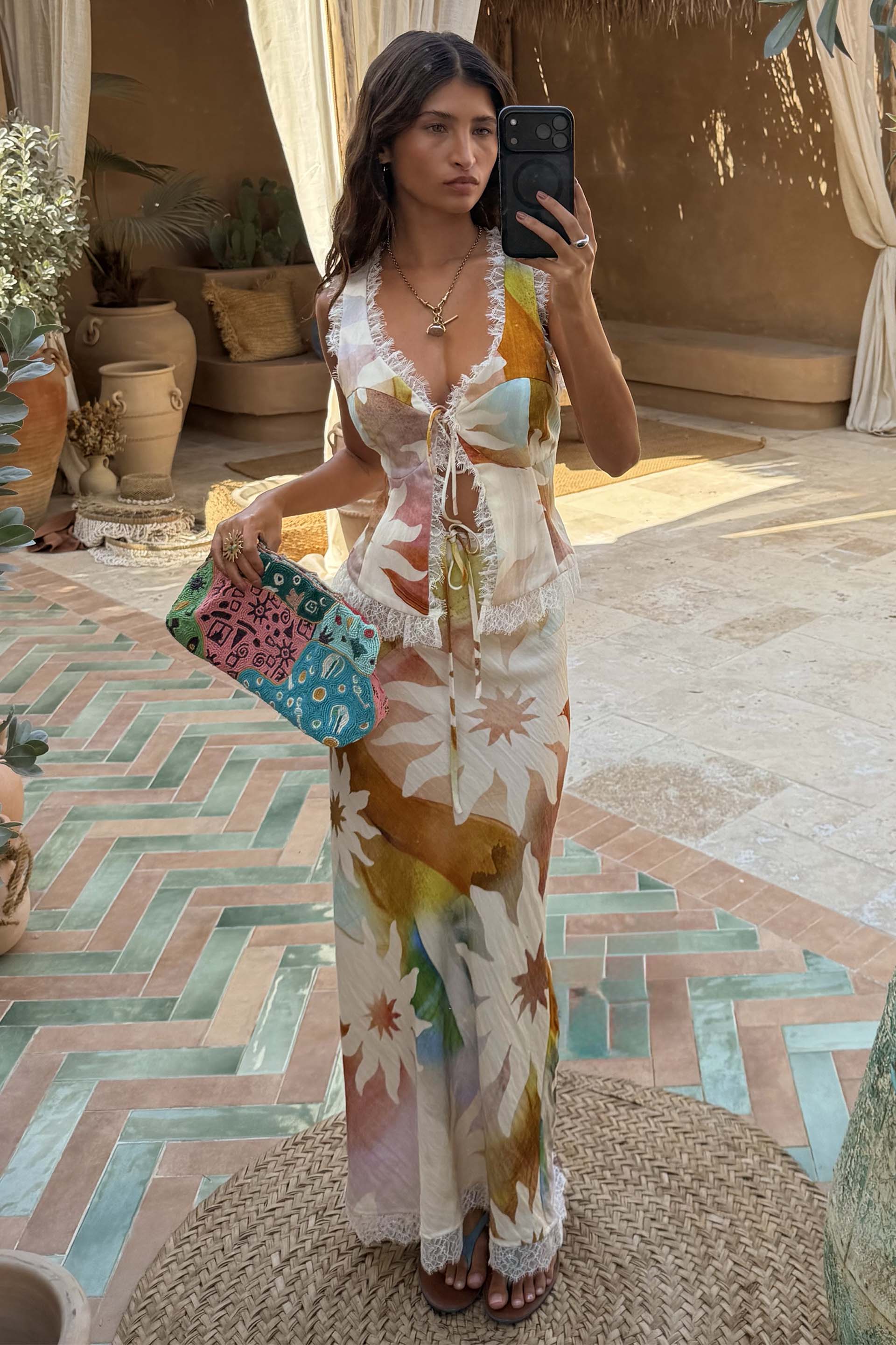 Abstract Soleil Mabel Skirt and matching top co-ord with sun motifs and white lace trim in an outdoor patio setting.