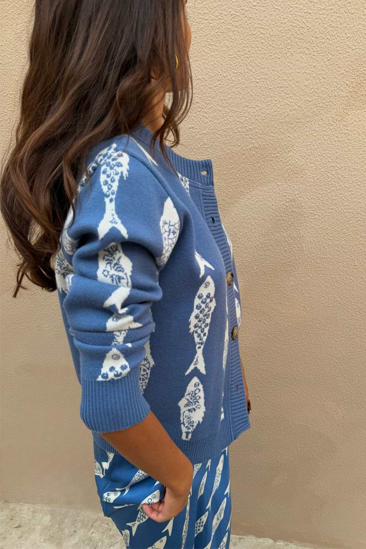 Blue Marina Hollie Cardigan in a soft knit with white fish motifs and buttons, part of an ocean blue co-ord.