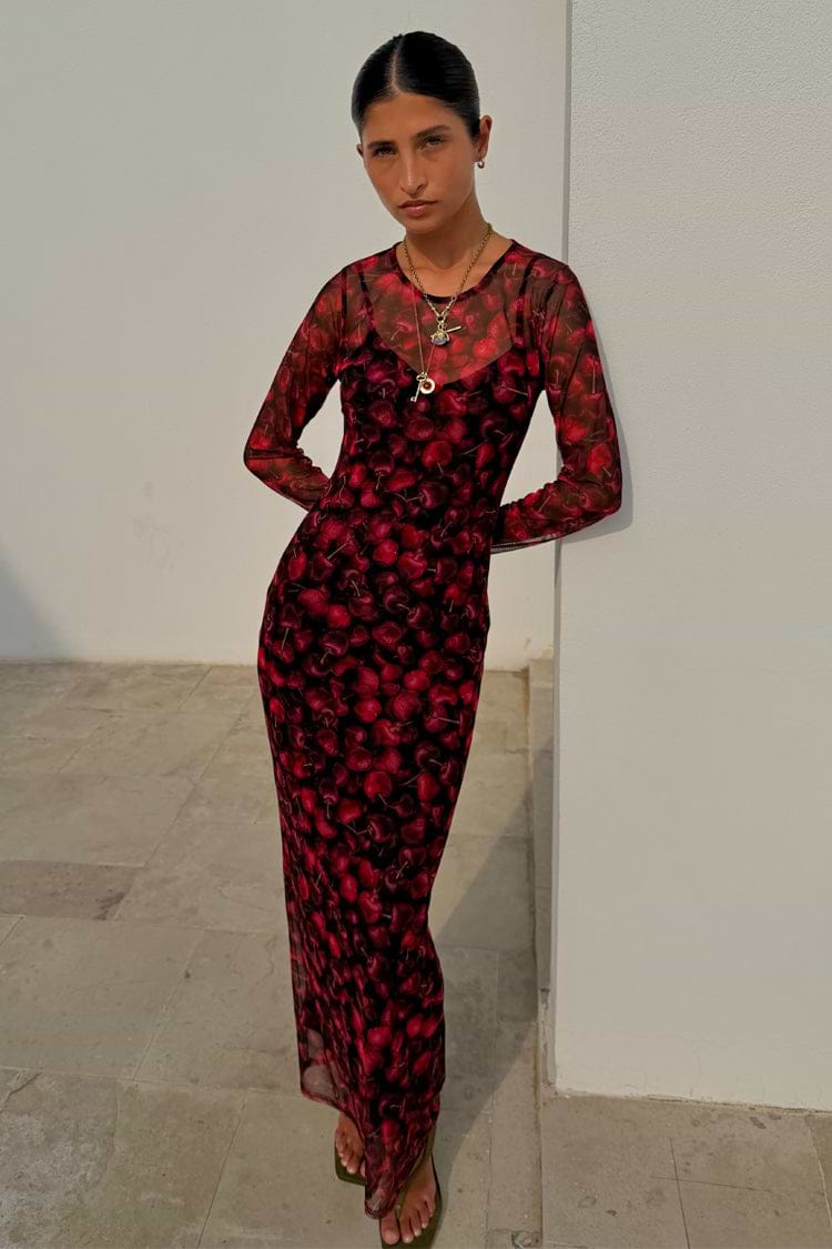 Cherry Mesh Soho Dress with a red digital cherry print, sheer long sleeves and a maxi length, worn by a model.