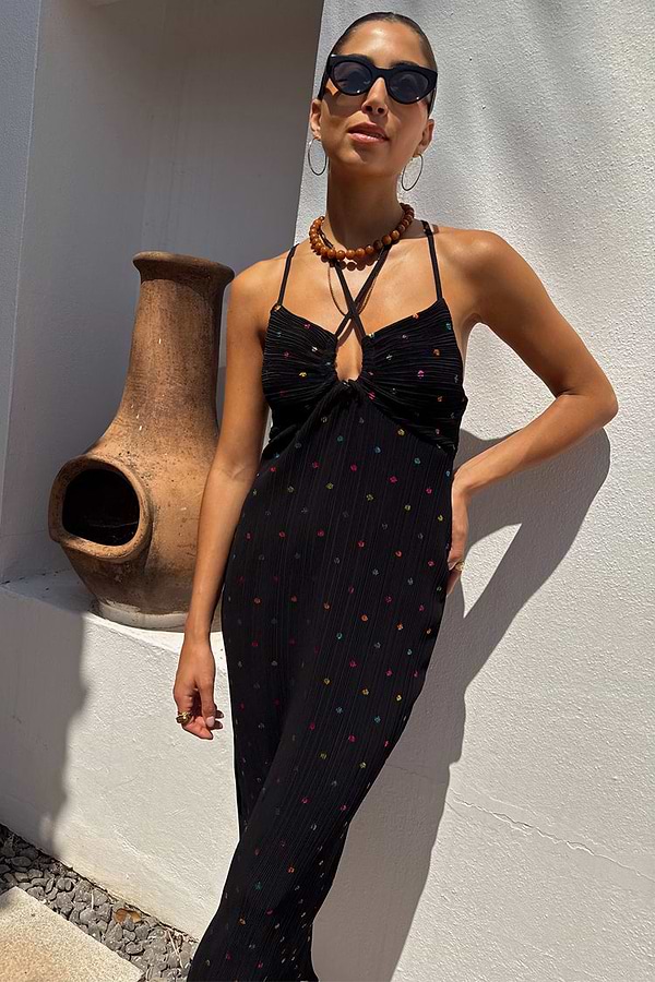 Multi Spot Megan Dress in black plisse with colourful flecks and a crossover strappy neckline on a model.