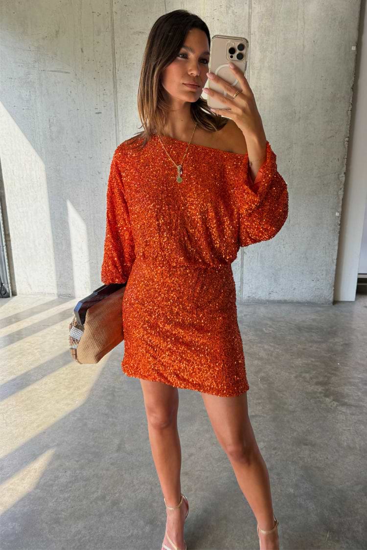 Orange Sequin Tilly Dress Petite with an off-the-shoulder neckline and long sleeves, shown in a mirror selfie.