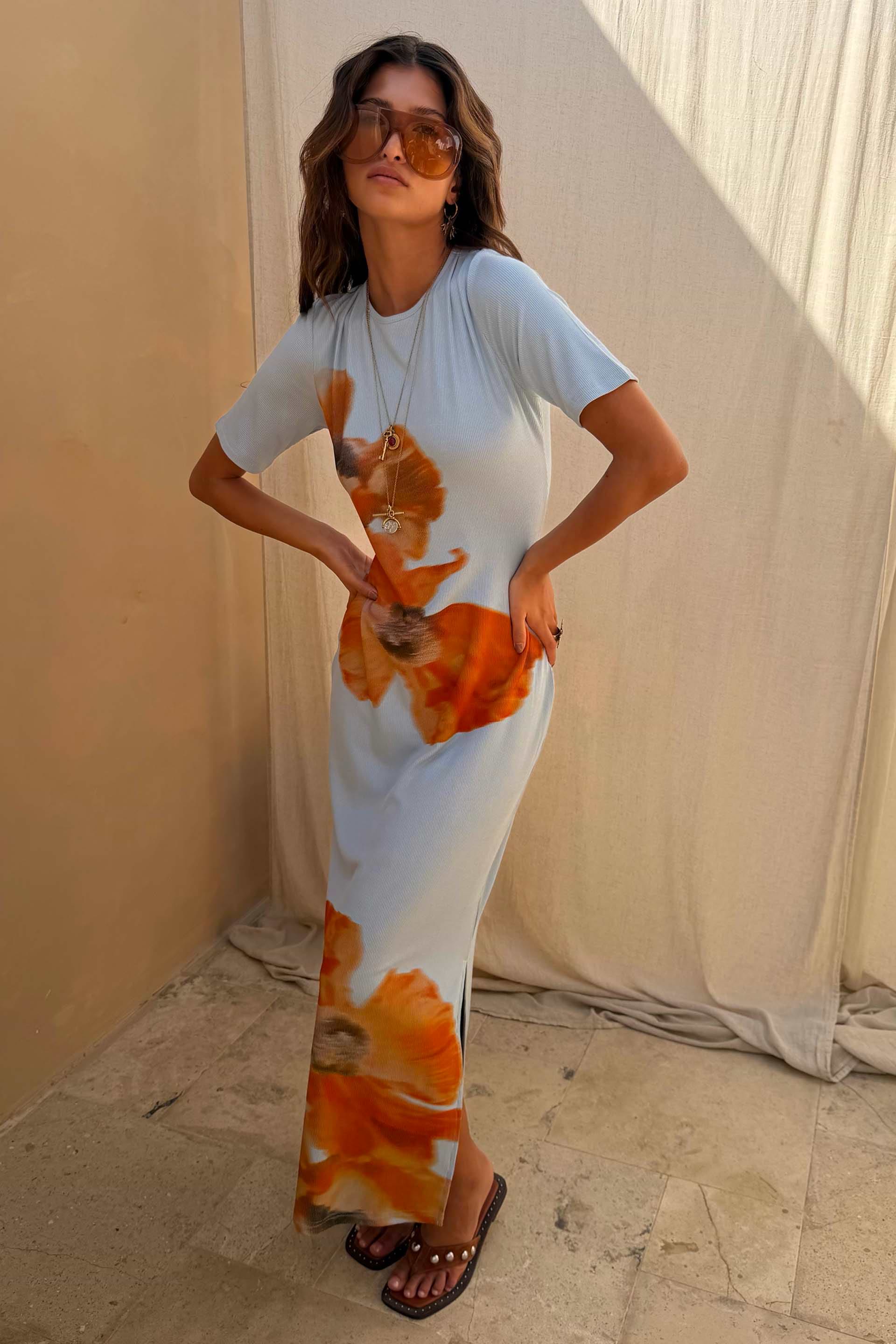 Orange Acetate Visor Sunglasses with tinted lenses worn with a light blue floral ribbed midi dress.